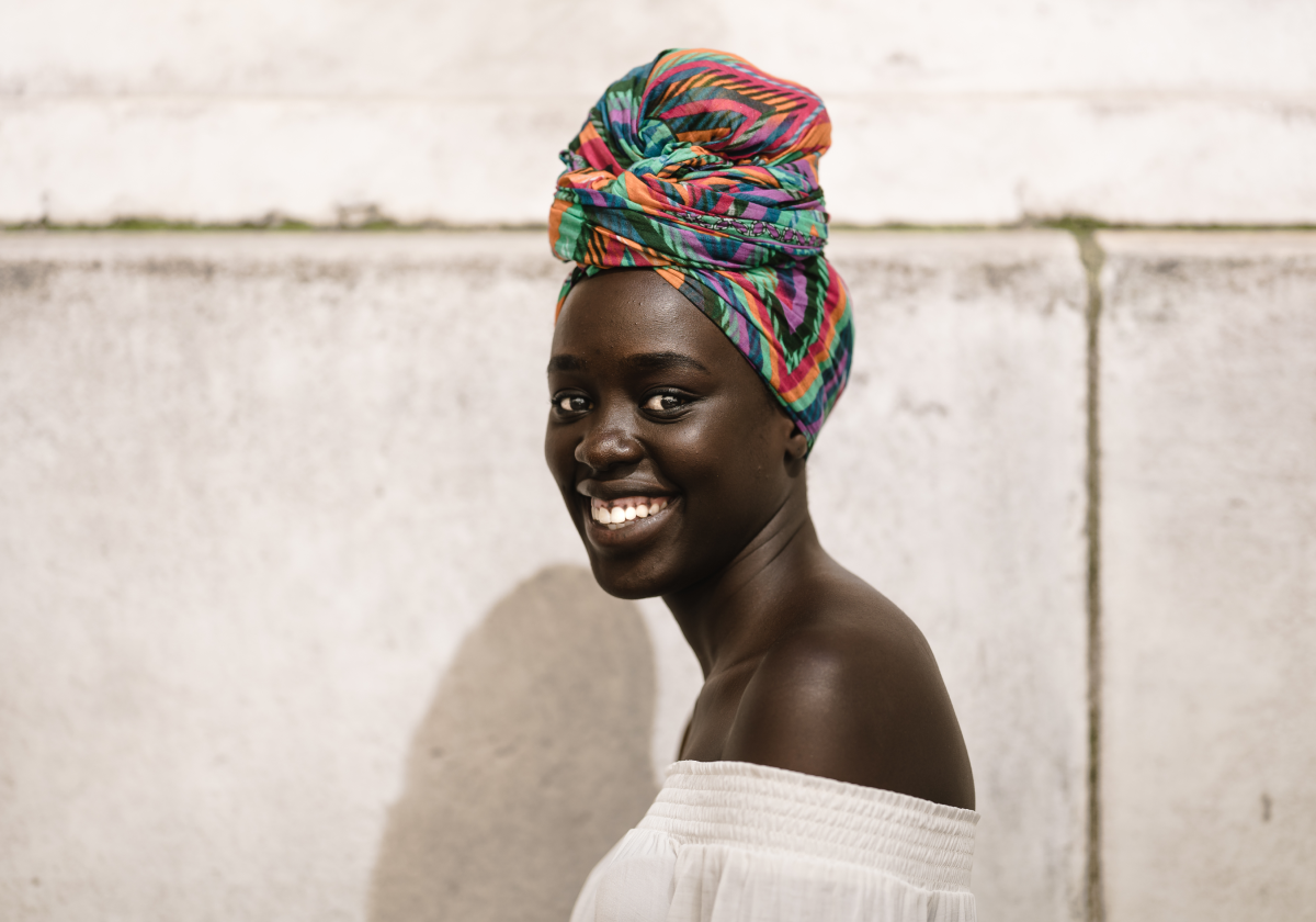 Woman wearing traditional clothing smiling in South Sudan