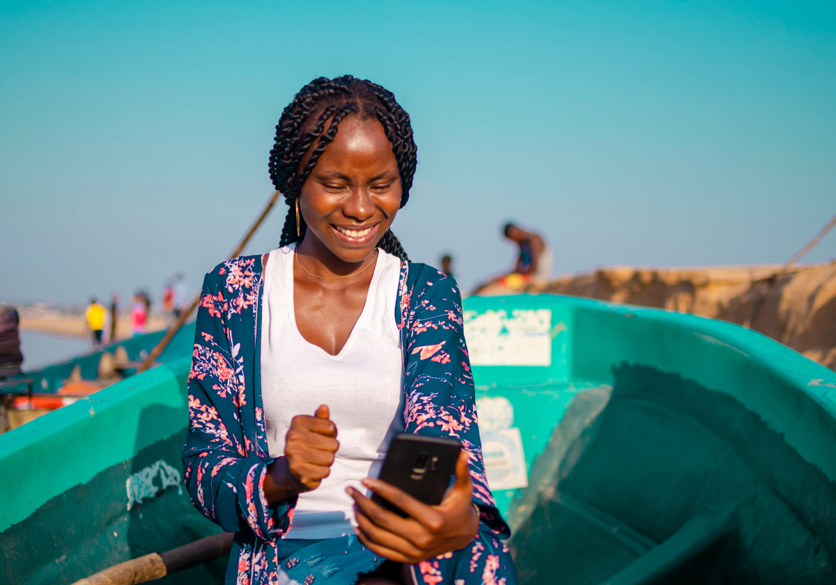 Woman using a mobile phone on a small boat in the Central African Republic